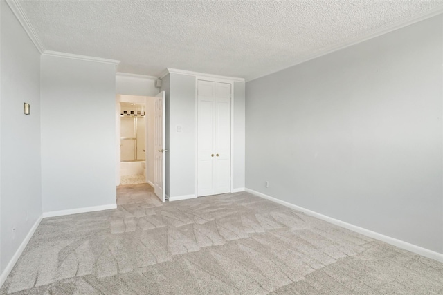 unfurnished bedroom featuring baseboards, ornamental molding, carpet flooring, a closet, and a textured ceiling