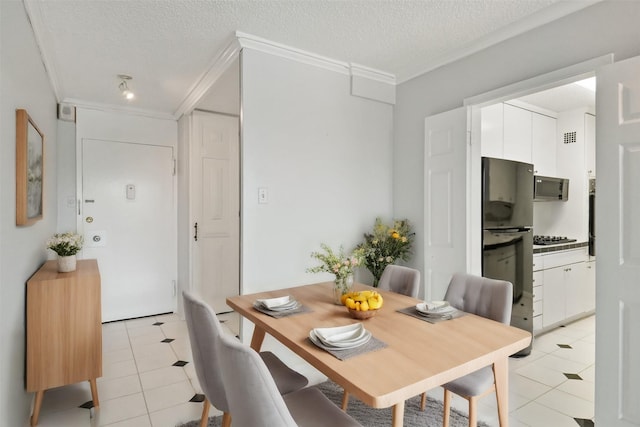 dining area featuring a textured ceiling, ornamental molding, and light tile patterned flooring