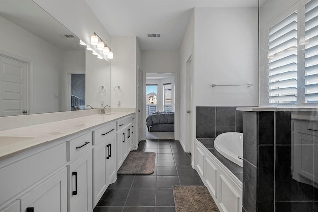 ensuite bathroom with double vanity, visible vents, a sink, ensuite bath, and tile patterned flooring