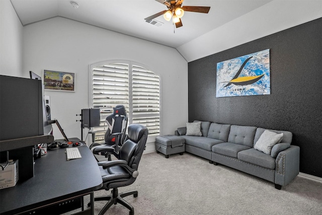 carpeted home office featuring vaulted ceiling, ceiling fan, visible vents, and baseboards