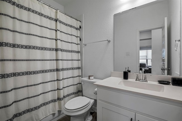 bathroom featuring a textured wall, curtained shower, toilet, visible vents, and vanity