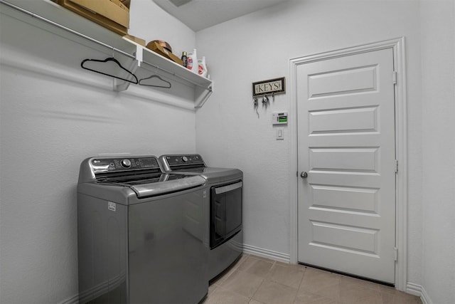 laundry area featuring laundry area, washing machine and dryer, and baseboards