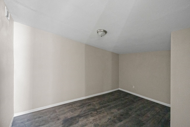 6518 Meade St, Dallas, TX 75232 - empty room with visible vents, baseboards, vaulted ceiling, and dark wood-style flooring