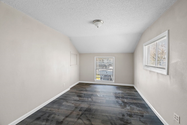 6518 Meade St, Dallas, TX 75232 - empty room featuring a healthy amount of sunlight, vaulted ceiling, and dark wood finished floors