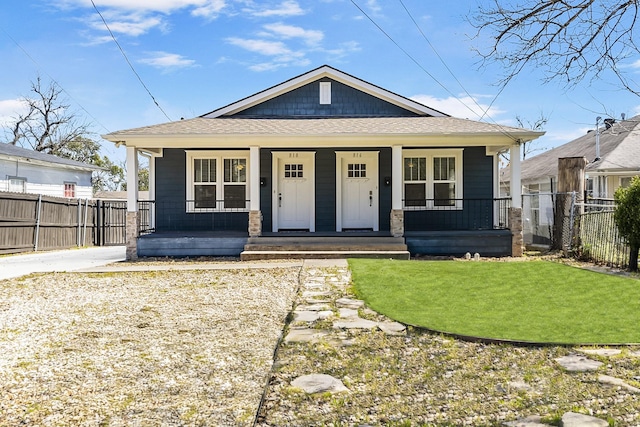 view of front facade featuring a porch, fence, and a front yard