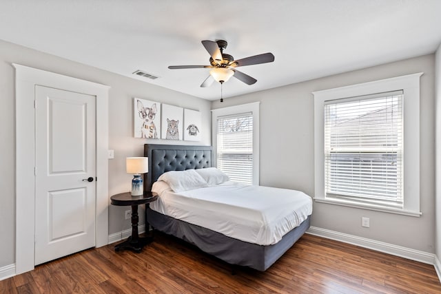 bedroom featuring wood finished floors, visible vents, and baseboards