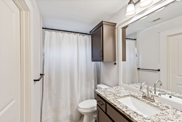 full bath featuring vanity, toilet, and visible vents