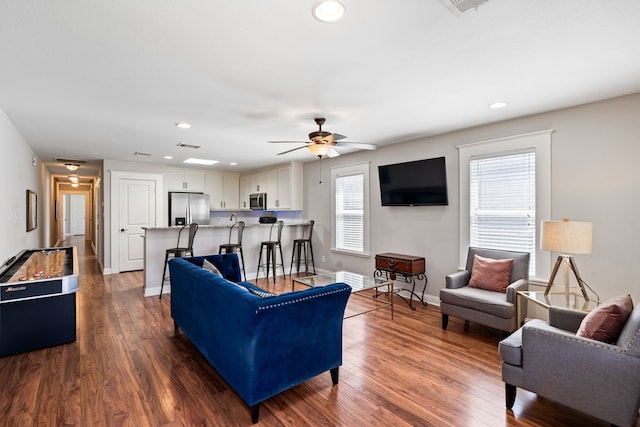 living room with recessed lighting, baseboards, and dark wood-style flooring