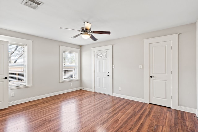 unfurnished bedroom with multiple windows, wood finished floors, visible vents, and baseboards