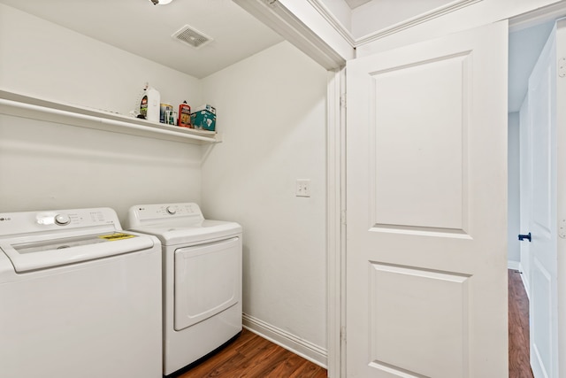 clothes washing area featuring baseboards, visible vents, laundry area, dark wood-style flooring, and washing machine and dryer