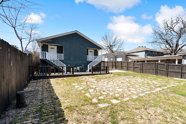 back of house featuring a yard, a fenced backyard, and stairway