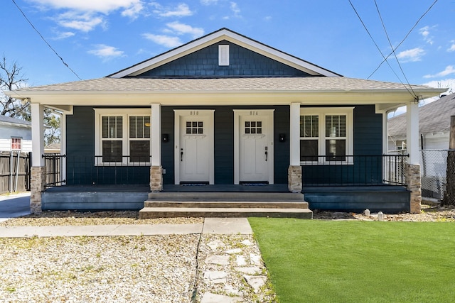 bungalow-style house featuring covered porch, a front lawn, and fence