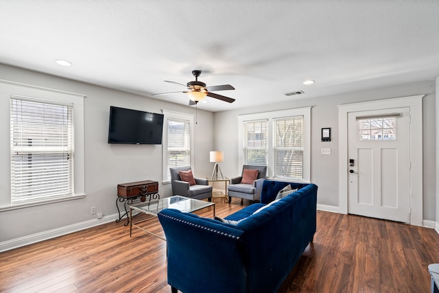 living room featuring recessed lighting, wood finished floors, visible vents, and baseboards