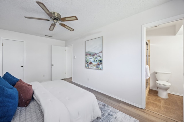 bedroom featuring a textured ceiling, wood finished floors, and visible vents