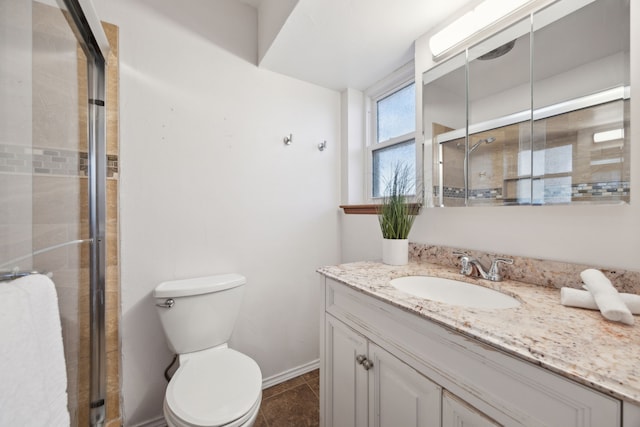 full bathroom with toilet, a shower stall, vanity, baseboards, and tile patterned floors