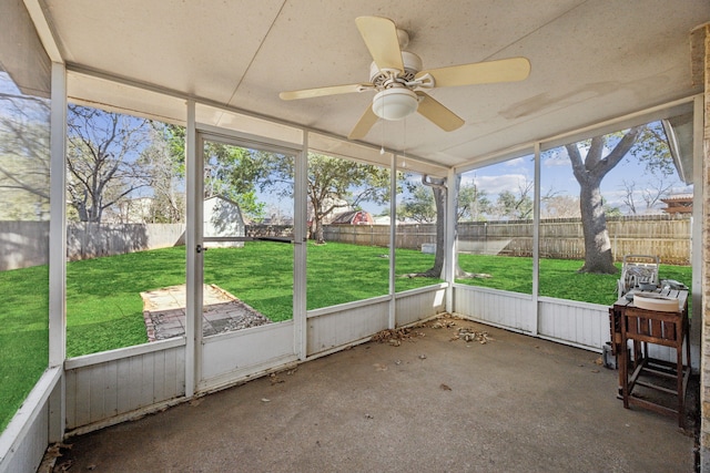 unfurnished sunroom with ceiling fan