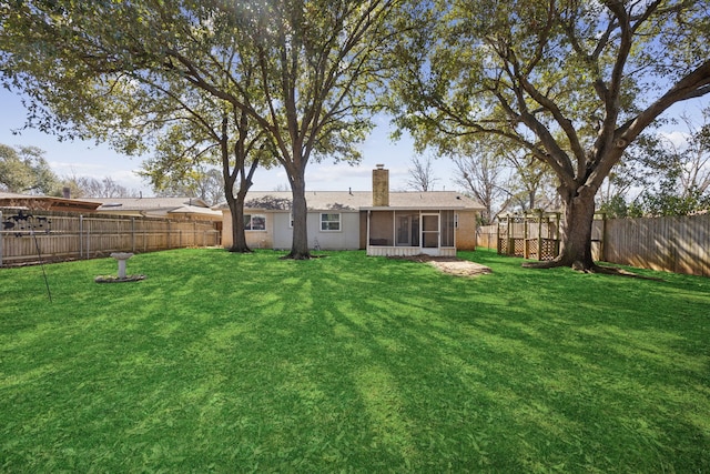 view of yard with a fenced backyard and a sunroom