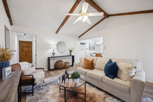 living room with vaulted ceiling with beams, a textured ceiling, and wood finished floors