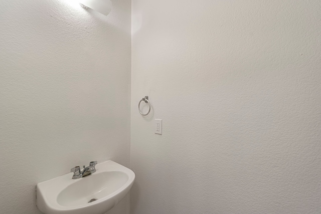 bathroom with a textured wall and a sink