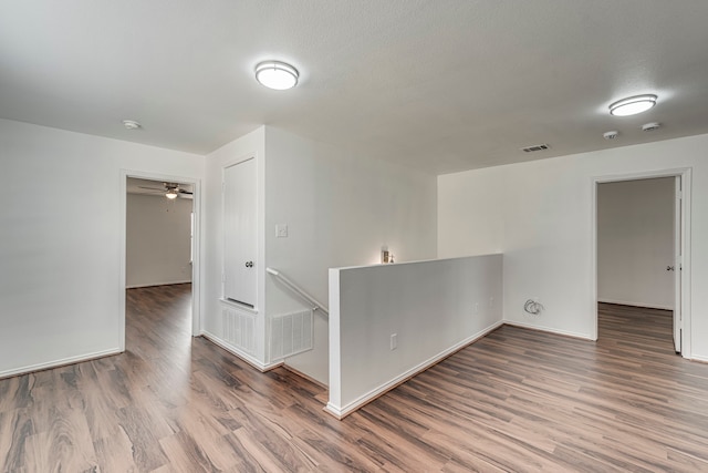 spare room with visible vents, baseboards, and wood finished floors