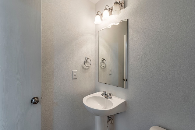 bathroom with a sink and a textured wall