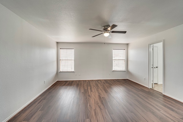 empty room with dark wood-style floors, a textured ceiling, baseboards, and a ceiling fan