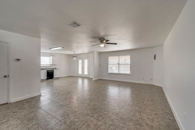 unfurnished living room featuring tile patterned floors, visible vents, baseboards, and ceiling fan