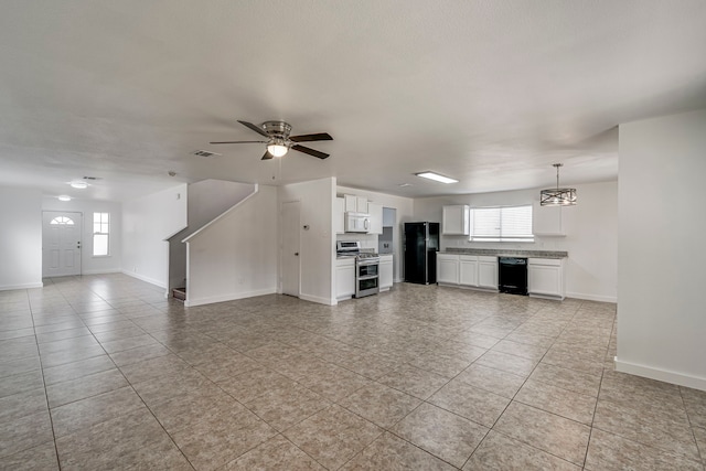 unfurnished living room with a ceiling fan, baseboards, and a wealth of natural light