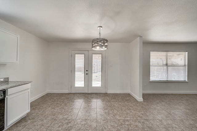 unfurnished dining area featuring light tile patterned floors, french doors, baseboards, and a textured ceiling