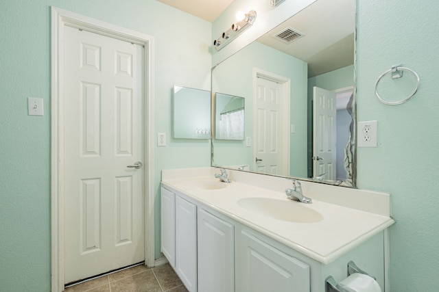 full bathroom with double vanity, visible vents, a sink, and tile patterned floors