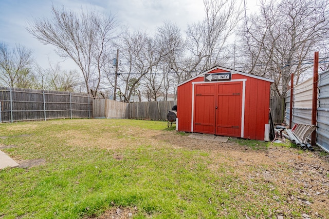 view of yard with a fenced backyard, a storage unit, and an outdoor structure