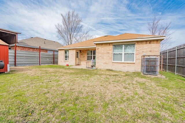 back of house featuring a lawn, cooling unit, and a fenced backyard