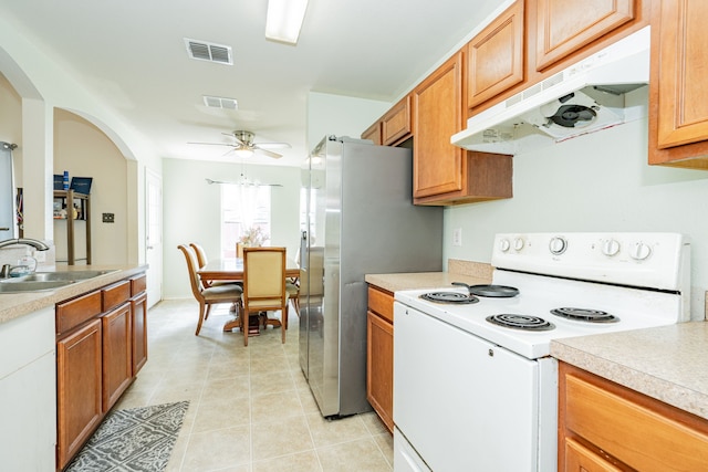 kitchen with white electric range oven, under cabinet range hood, visible vents, and a sink