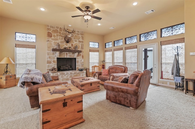 carpeted living room with recessed lighting, visible vents, a stone fireplace, and a ceiling fan