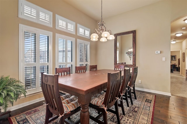 dining space featuring an inviting chandelier, arched walkways, baseboards, and wood-type flooring