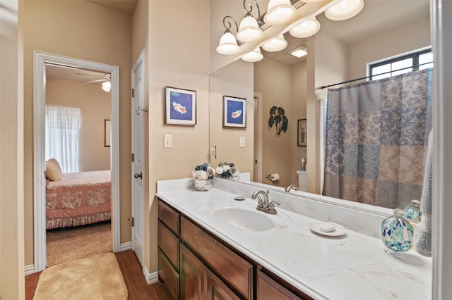 bathroom with toilet, vanity, wood finished floors, ensuite bath, and a ceiling fan