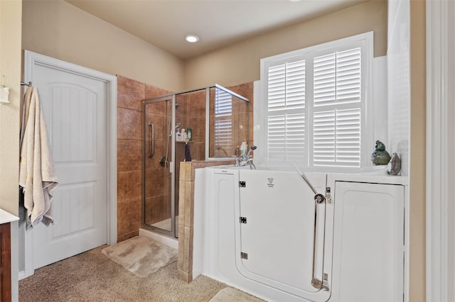 full bathroom featuring washer / clothes dryer, a shower stall, and a washtub