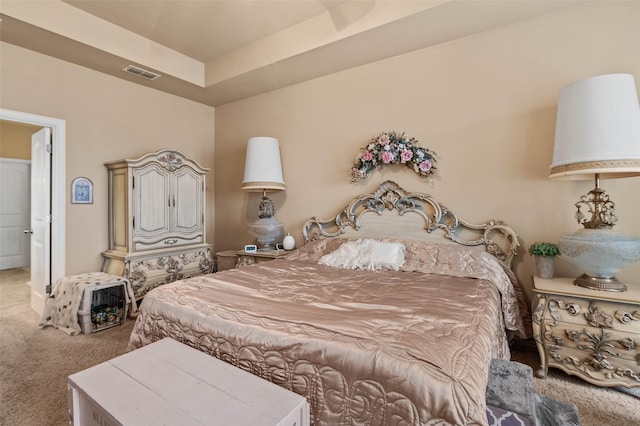 bedroom featuring visible vents, a raised ceiling, and carpet flooring