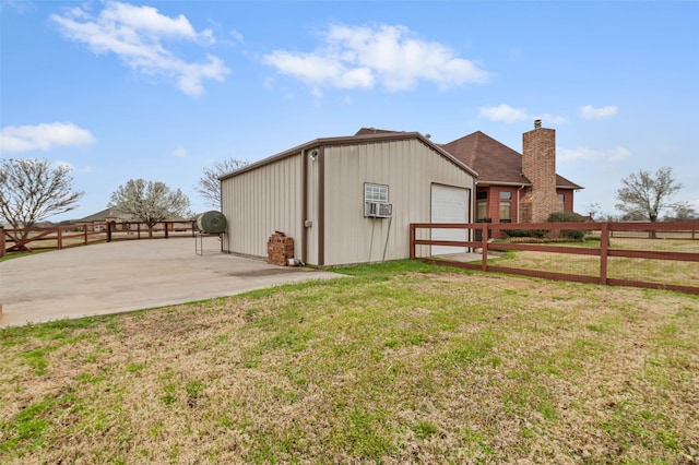 view of outbuilding with cooling unit, fence, and a garage