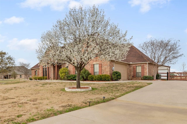 view of front facade featuring brick siding, driveway, and a garage