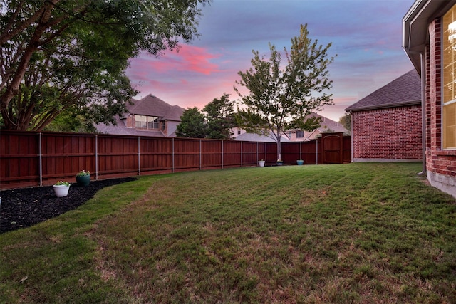 yard at dusk with a fenced backyard