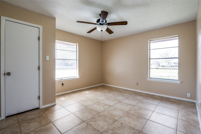 unfurnished room featuring light tile patterned floors, baseboards, a textured ceiling, and a ceiling fan