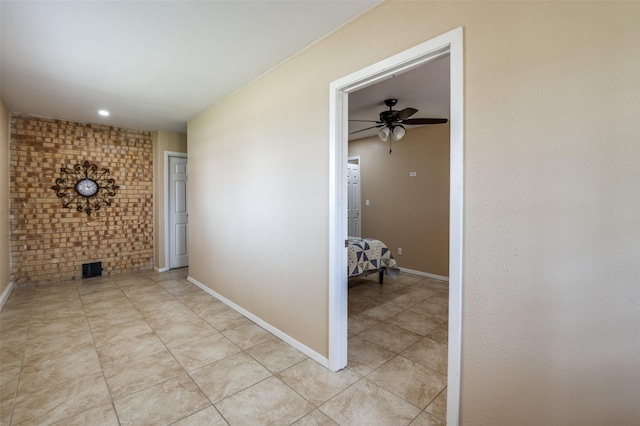 hallway with light tile patterned floors and baseboards