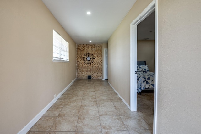 hallway featuring light tile patterned floors and baseboards