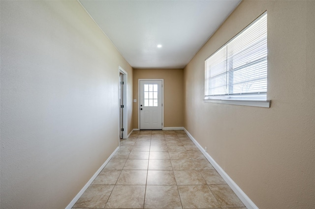 doorway to outside with light tile patterned floors and baseboards
