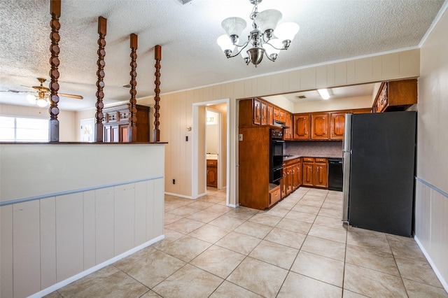 kitchen featuring brown cabinets, a notable chandelier, black dishwasher, freestanding refrigerator, and light tile patterned floors