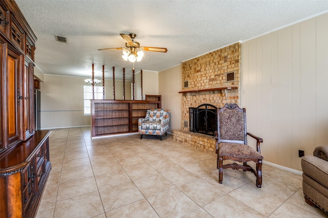 sitting room featuring visible vents, ornamental molding, a textured ceiling, a fireplace, and ceiling fan