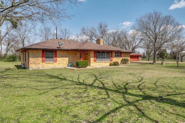 view of front of house featuring brick siding, a chimney, and a front yard