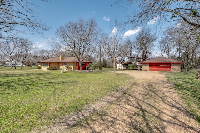 view of yard featuring a detached garage, a carport, and driveway