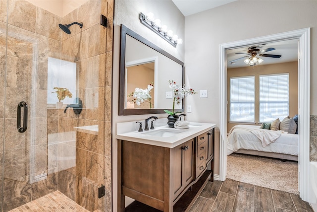 bathroom featuring double vanity, a stall shower, connected bathroom, wood tiled floor, and a sink